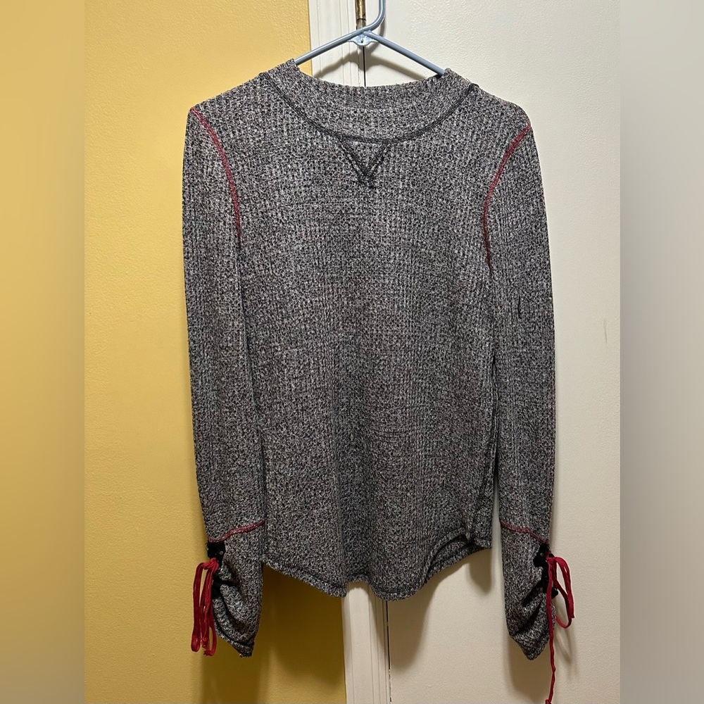 FREE PEOPLE (L) CIRCLE HEM MARBLED BLACK/WHITE LONG SLEEVE TOP WITH RED TRIM.